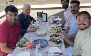 5 people eating lunch during a sunny day.
