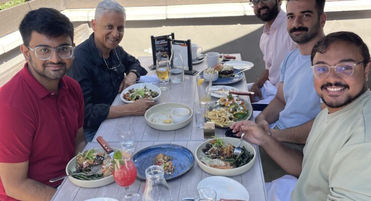 5 people eating lunch during a sunny day.